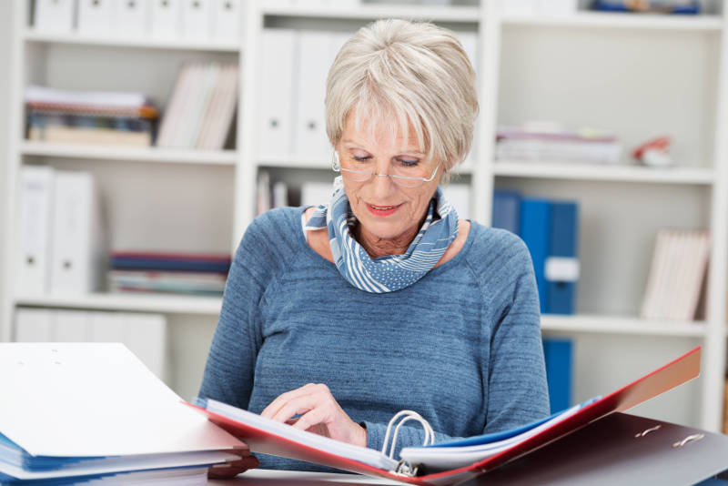 older woman looking at business report